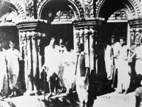 Gandhiji coming out of a burnt pucca building. Haran Ghosh Chowdhury standing behind with a piece of paper on 8th February, 1947 at Nandigram in Noakhali.jpg